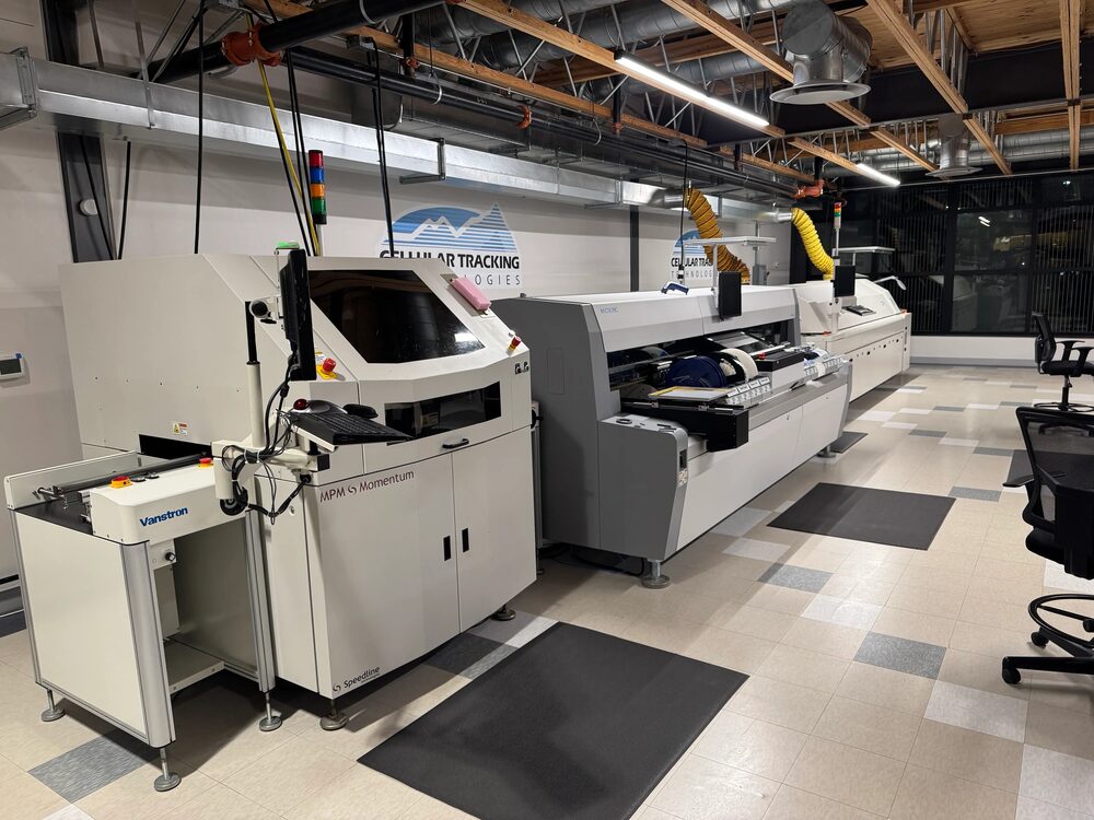 The Cellular Tracking Technologies surface-mount line: stencil printer, pick-and-place, and reflow oven in a row on the production floor.